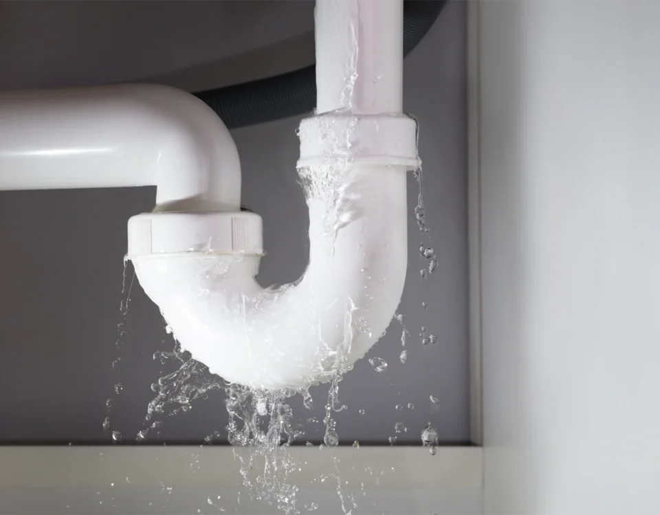 How to Fix a Leaking Pipe — under-sink pipe dripping into a bucket
