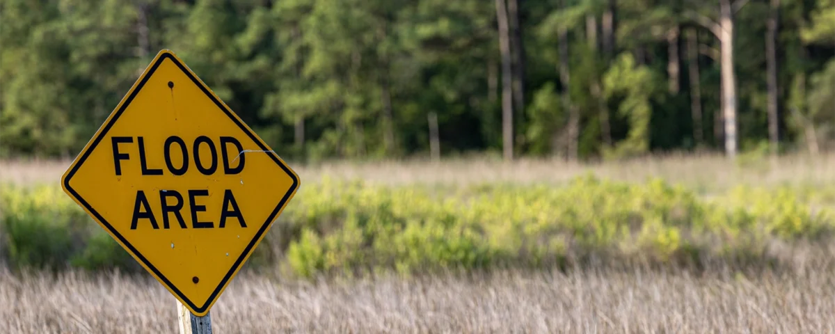 Yellow “Flood Area” warning sign near a Sacramento roadway, highlighting local flood zone risks